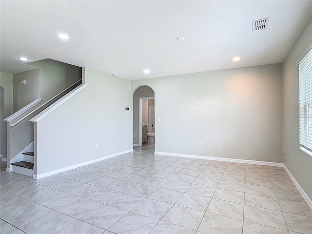 3975 Silverstream Ter, Sanford, FL 32771 - unfurnished room featuring arched walkways, recessed lighting, light tile patterned floors, and stairs
