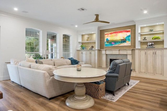 6047 Blakeford Dr, Windermere, FL 34786 - living room with crown molding, light wood-style flooring, a fireplace, built in features, and a ceiling fan