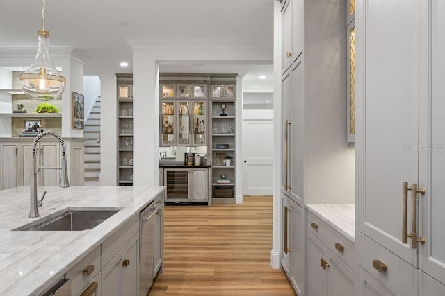 6047 Blakeford Dr, Windermere, FL 34786 - kitchen with wine cooler, light wood-type flooring, ornamental molding, stainless steel dishwasher, and pendant lighting