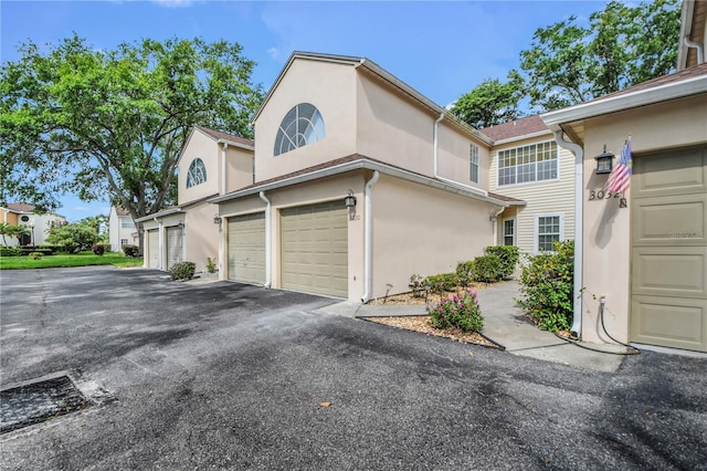 3030 Clubview Dr Unit Ge, Orlando, FL 32822 - view of property exterior with stucco siding and asphalt driveway