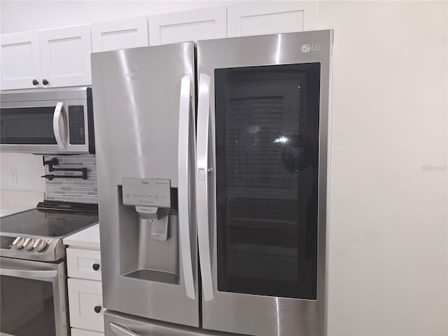 3030 Clubview Dr Unit Ge, Orlando, FL 32822 - kitchen featuring appliances with stainless steel finishes, white cabinetry, and tasteful backsplash