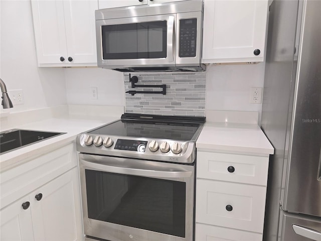 3030 Clubview Dr Unit Ge, Orlando, FL 32822 - kitchen with stainless steel appliances, decorative backsplash, white cabinets, and light countertops