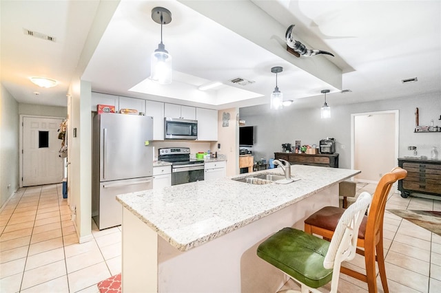 236 Longhorn Dr, Apopka, FL 32712 - kitchen featuring stainless steel appliances, light tile patterned floors, white cabinetry, and a kitchen breakfast bar