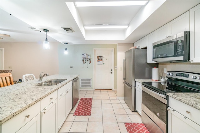 236 Longhorn Dr, Apopka, FL 32712 - kitchen with stainless steel appliances, light tile patterned floors, a raised ceiling, and white cabinetry