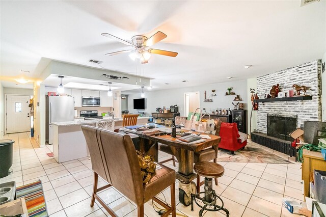 236 Longhorn Dr, Apopka, FL 32712 - dining area with light tile patterned floors, ceiling fan, and a fireplace