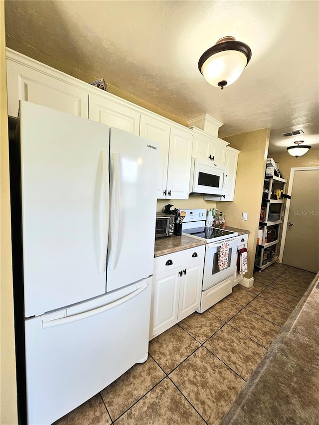 5037 S Obispo Cir, Labelle, FL 33935 - kitchen with white appliances, dark tile patterned flooring, and white cabinets