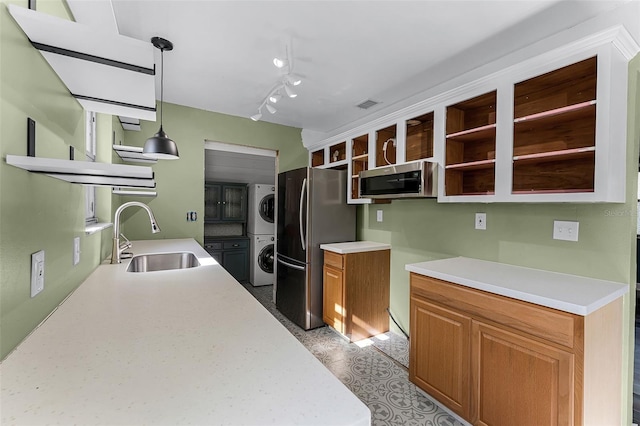 2915 Dean Ridge Rd, Orlando, FL 32825 - kitchen featuring estacked washer and dryer, appliances with stainless steel finishes, open shelves, light countertops, and hanging light fixtures