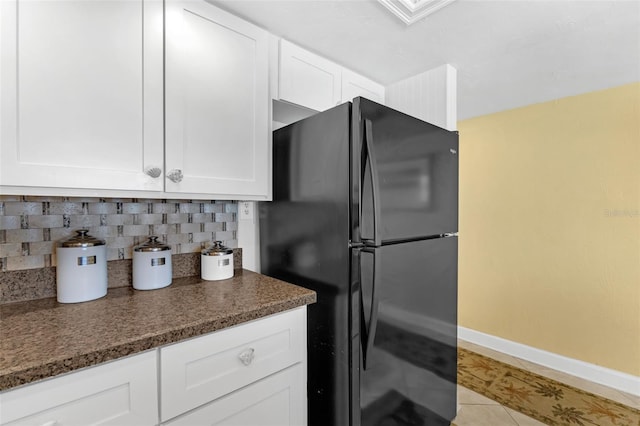 4141 S Atlantic Ave Unit 707, New Smyrna Beach, FL 32169 - kitchen featuring freestanding refrigerator, tasteful backsplash, white cabinets, and light tile patterned floors