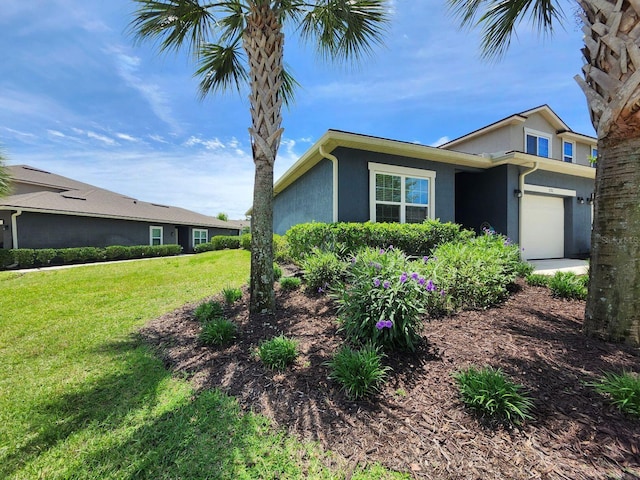 3281 Chestnut Ridge Way, Orange Park, FL 32065 - view of side of property featuring stucco siding, a yard, and a garage