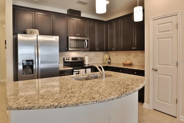 3281 Chestnut Ridge Way, Orange Park, FL 32065 - kitchen with appliances with stainless steel finishes, dark brown cabinets, light stone countertops, backsplash, and light tile patterned floors