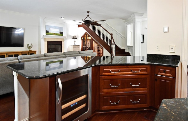 1653 Cheyenne Trl, Maitland, FL 32751 - kitchen with beverage cooler, dark wood-style flooring, a glass covered fireplace, a ceiling fan, and dark stone counters