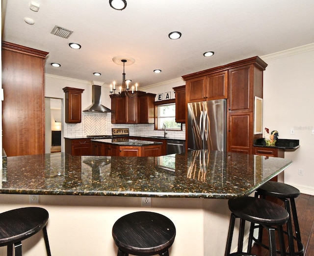 1653 Cheyenne Trl, Maitland, FL 32751 - kitchen featuring appliances with stainless steel finishes, wall chimney range hood, ornamental molding, tasteful backsplash, and dark wood-style flooring