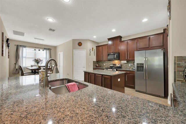 2319 Dammar St, Orlando, FL 32824 - kitchen with stainless steel appliances, decorative backsplash, stone countertops, decorative light fixtures, and recessed lighting