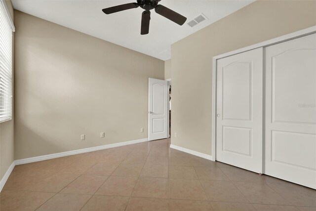 2319 Dammar St, Orlando, FL 32824 - unfurnished bedroom featuring light tile patterned floors, a closet, and a ceiling fan