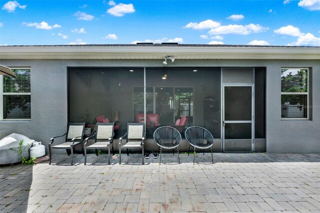 2319 Dammar St, Orlando, FL 32824 - rear view of house with a patio area, stucco siding, and a sunroom