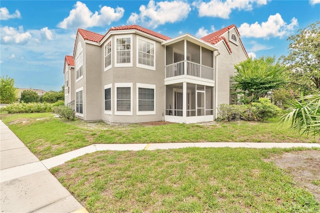 900 Northern Dancer Way Unit 204, Casselberry, FL 32707 - back of house featuring a sunroom, a lawn, stucco siding, and a tiled roof