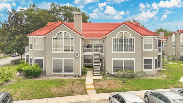 900 Northern Dancer Way Unit 204, Casselberry, FL 32707 - back of property featuring a chimney, stairway, stucco siding, and a tiled roof