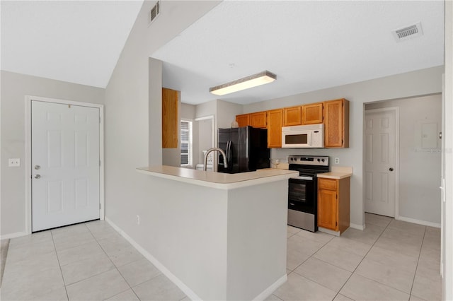 900 Northern Dancer Way Unit 204, Casselberry, FL 32707 - kitchen with freestanding refrigerator, white microwave, stainless steel electric stove, light tile patterned floors, and light countertops