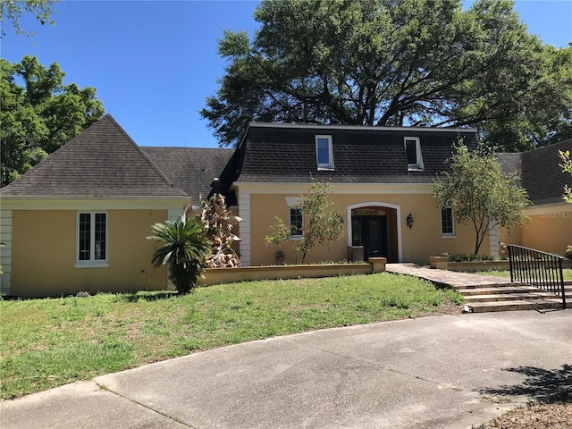 1910 NW 13th Pl, Ocala, FL 34475 - view of front property featuring a shingled roof, stucco siding, and a front yard