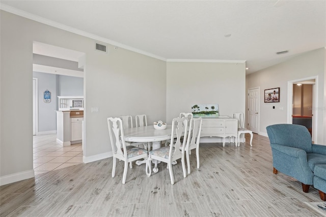4650 Links Village Dr Unit B103, Ponce Inlet, FL 32127 - dining area featuring light wood-style floors and crown molding