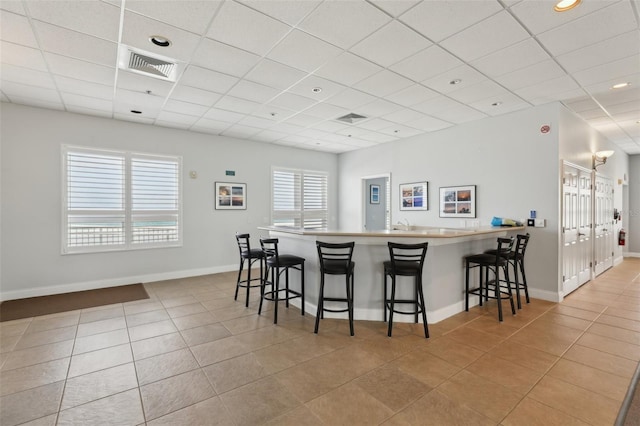 4650 Links Village Dr Unit B103, Ponce Inlet, FL 32127 - kitchen featuring tile patterned floors, a breakfast bar, a paneled ceiling, a peninsula, and recessed lighting