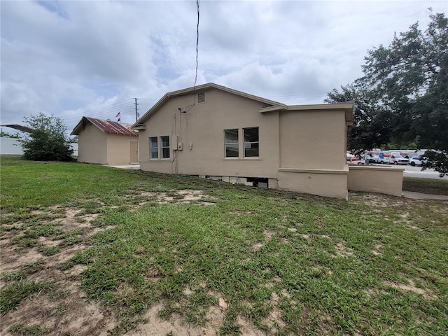 1020 E Main St, Haines City, FL 33844 - rear view of property with stucco siding and a yard
