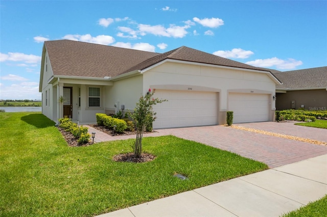 3240 Canna Lily Pl, Clermont, FL 34711 - single story home featuring decorative driveway, stucco siding, a front yard, a garage, and roof with shingles