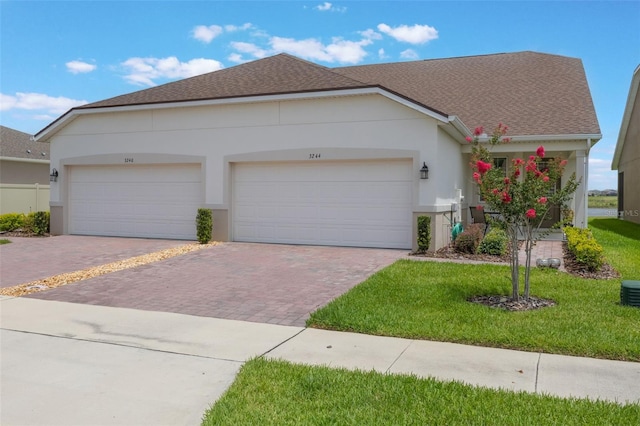 3240 Canna Lily Pl, Clermont, FL 34711 - ranch-style home featuring decorative driveway, stucco siding, a front yard, and roof with shingles