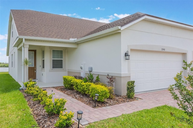 3240 Canna Lily Pl, Clermont, FL 34711 - view of front facade featuring an attached garage, stucco siding, roof with shingles, and driveway