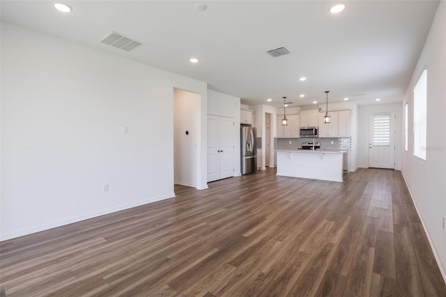 3240 Canna Lily Pl, Clermont, FL 34711 - unfurnished living room with recessed lighting and dark wood-type flooring