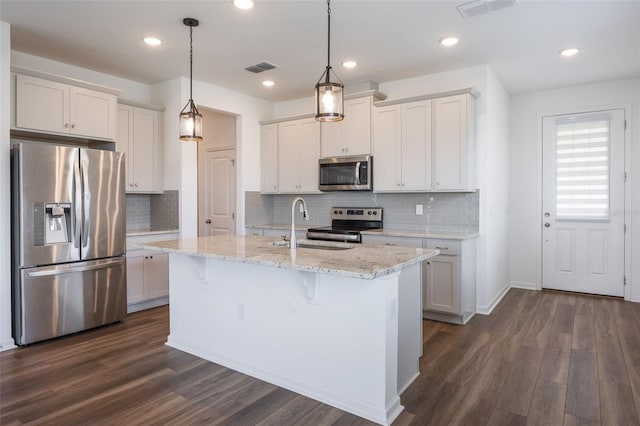 3240 Canna Lily Pl, Clermont, FL 34711 - kitchen with stainless steel appliances, dark wood-style floors, tasteful backsplash, white cabinetry, and recessed lighting