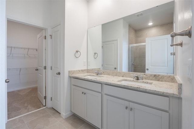 3240 Canna Lily Pl, Clermont, FL 34711 - full bath featuring a stall shower, double vanity, a spacious closet, and tile patterned floors