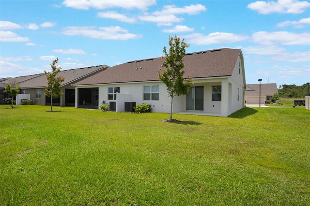 3240 Canna Lily Pl, Clermont, FL 34711 - rear view of house featuring a lawn, stucco siding, and a shingled roof