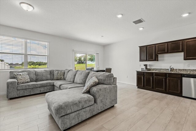 827 Grandin St, Davenport, FL 33837 - living room featuring light wood-type flooring, recessed lighting, and a textured ceiling