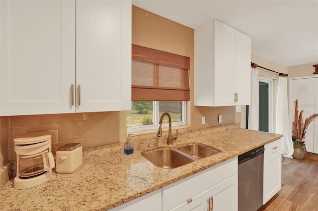 1000 Sal St, Ocoee, FL 34761 - kitchen with stainless steel dishwasher, white cabinets, light stone counters, and tasteful backsplash