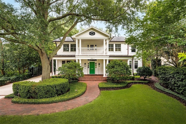 1011 Lake Davis Dr, Orlando, FL 32806 - greek revival house featuring a balcony, a front yard, and covered porch