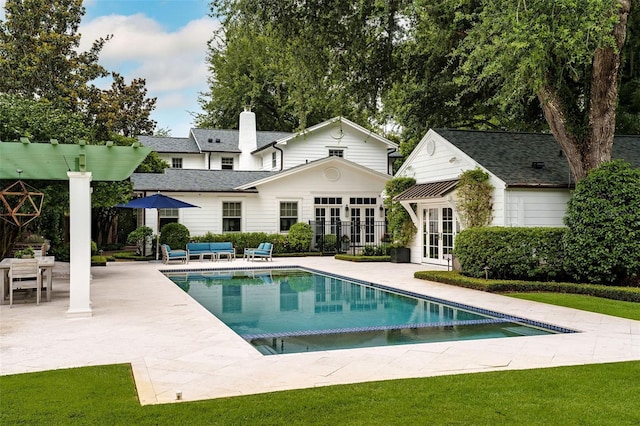 1011 Lake Davis Dr, Orlando, FL 32806 - rear view of house featuring a patio, an outdoor pool, french doors, a chimney, and an outdoor structure