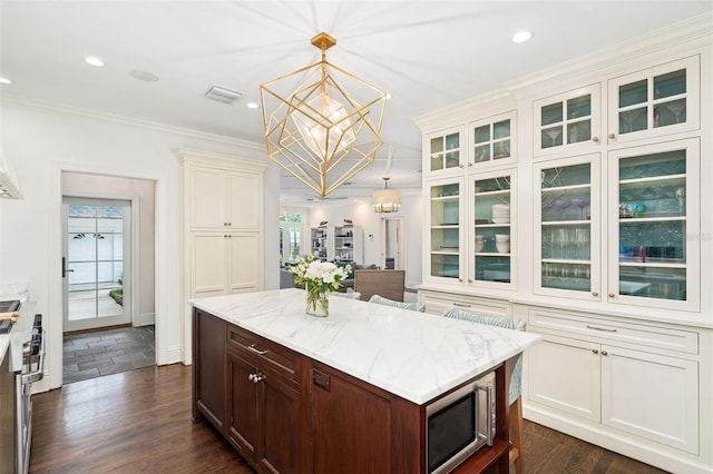 1011 Lake Davis Dr, Orlando, FL 32806 - kitchen featuring a chandelier, appliances with stainless steel finishes, light stone countertops, glass insert cabinets, and plenty of natural light