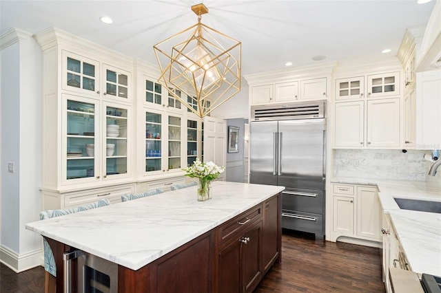 1011 Lake Davis Dr, Orlando, FL 32806 - kitchen with stainless steel built in refrigerator, beverage cooler, a chandelier, light stone countertops, and glass insert cabinets