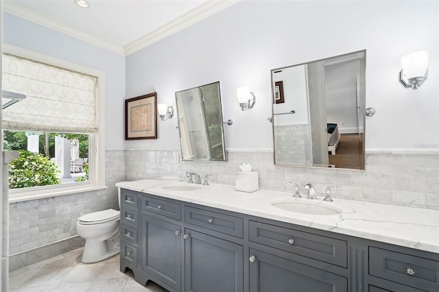 1011 Lake Davis Dr, Orlando, FL 32806 - full bathroom with tile walls, double vanity, crown molding, and a wainscoted wall