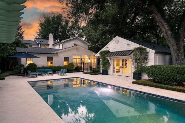 1011 Lake Davis Dr, Orlando, FL 32806 - pool at dusk featuring french doors, a patio, and an outdoor pool