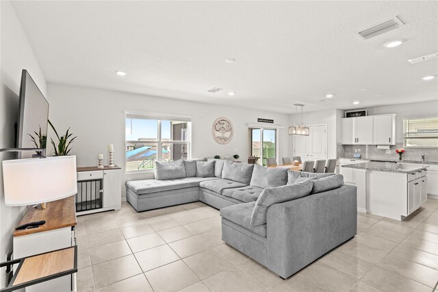 7603 Taormina Way, Clermont, FL 34714 - living room with healthy amount of natural light, light tile patterned floors, recessed lighting, and a textured ceiling