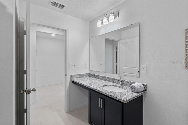 232 Summerlin Loop, Haines City, FL 33844 - bathroom with vanity, a textured ceiling, and tile patterned flooring