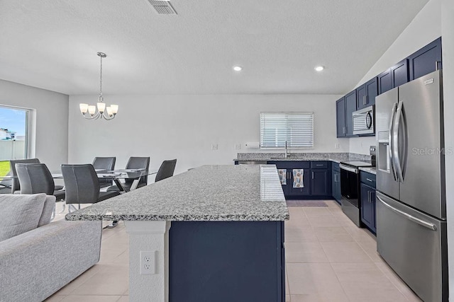 232 Summerlin Loop, Haines City, FL 33844 - kitchen with stainless steel appliances, a center island, light tile patterned flooring, a chandelier, and a textured ceiling