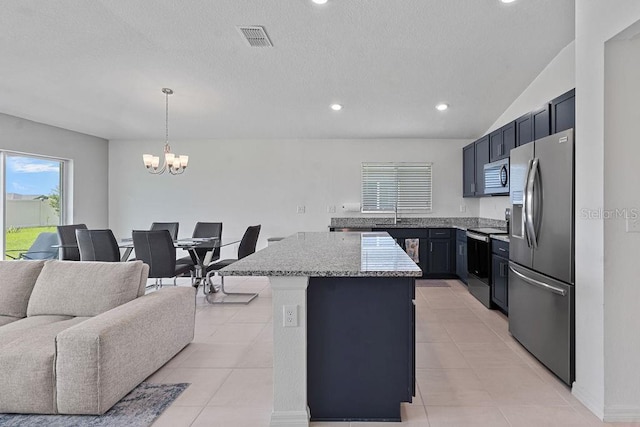 232 Summerlin Loop, Haines City, FL 33844 - kitchen featuring appliances with stainless steel finishes, a kitchen island, a chandelier, open floor plan, and light stone countertops