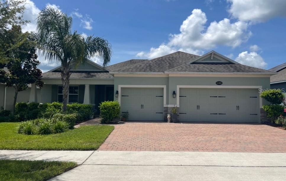 31961 Redtail Reserve Blvd, Sorrento, FL 32776 - single story home with a garage, decorative driveway, stucco siding, and roof with shingles