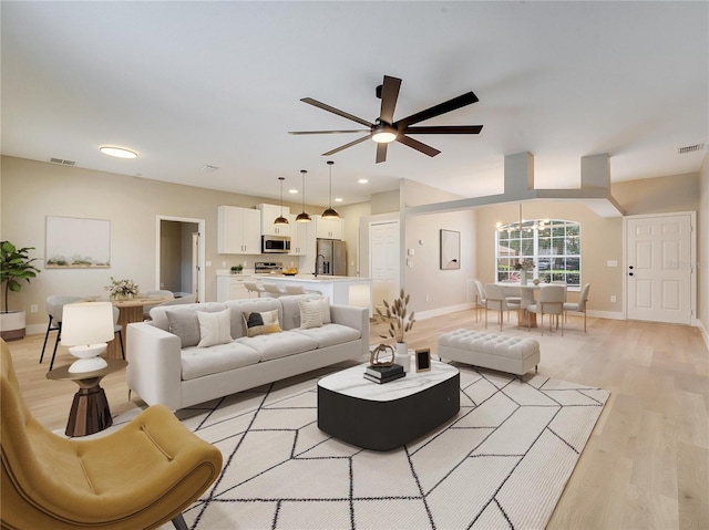 2823 NE 24th Pl, Ocala, FL 34470 - living room featuring light wood-type flooring, ceiling fan, a chandelier, and recessed lighting