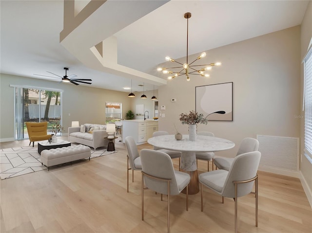 2823 NE 24th Pl, Ocala, FL 34470 - dining space with a chandelier, light wood-style flooring, and a ceiling fan