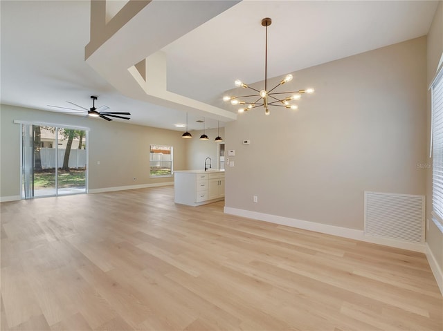2823 NE 24th Pl, Ocala, FL 34470 - unfurnished living room featuring a chandelier, ceiling fan, and light wood-style floors