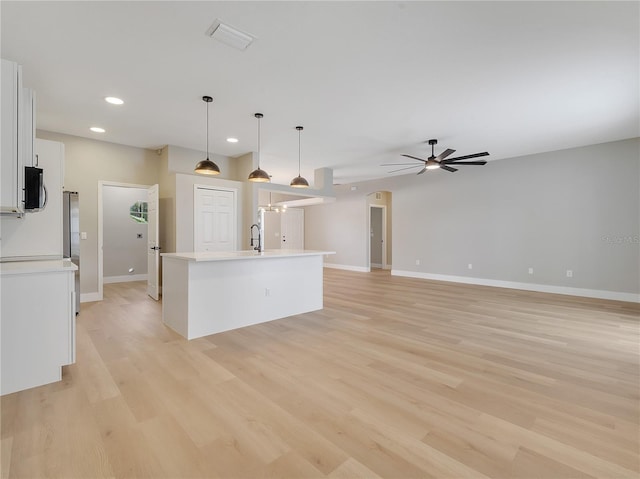 2823 NE 24th Pl, Ocala, FL 34470 - kitchen with white cabinets, a center island with sink, light countertops, recessed lighting, and a ceiling fan
